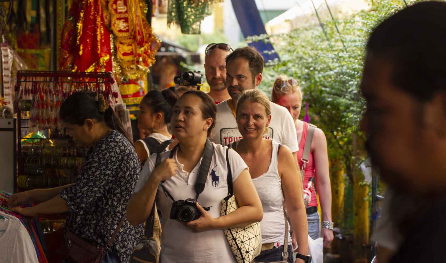 People walking through a crowded market street in Bangkok, Thailand.