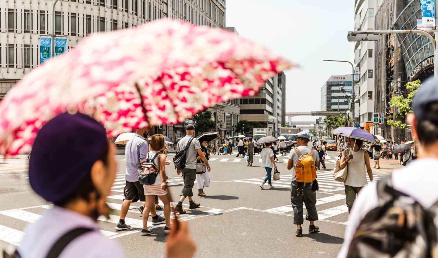 Pedestrians crossing a busy intersection in Kobe, Japan.