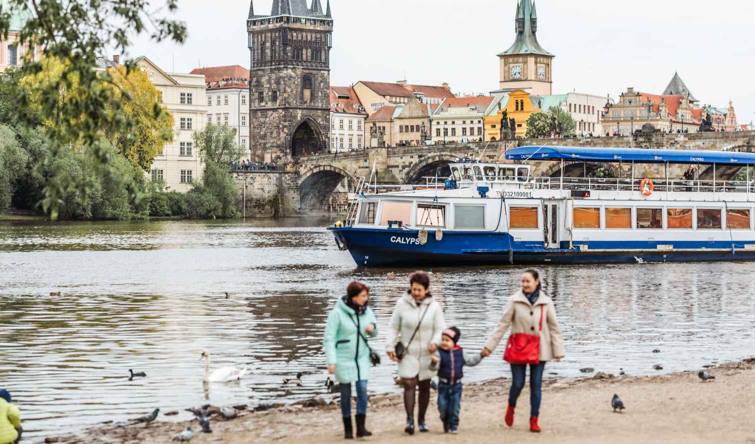 Charles Bridge and boats on the Vltava River in Prague.