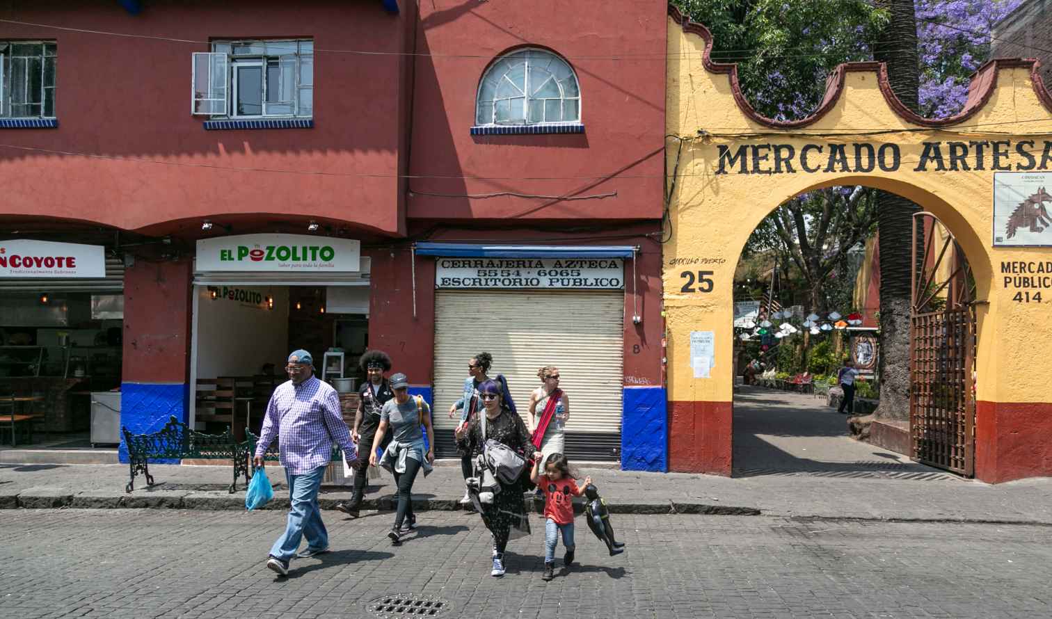 People walking past Mercado Artesanal in Coyoacán, Mexico City.