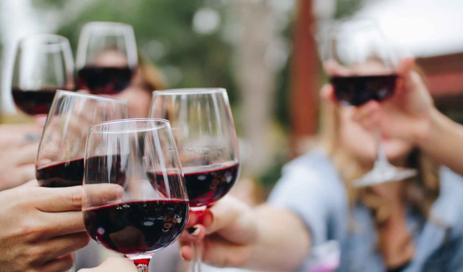 People clinking red wine glasses outdoors in Rome
