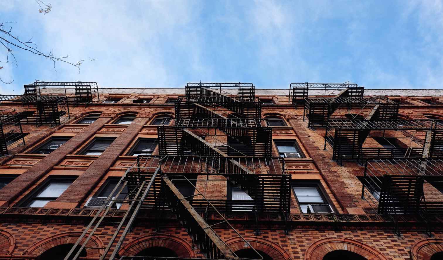 Fire escapes on a red brick building in New York City.