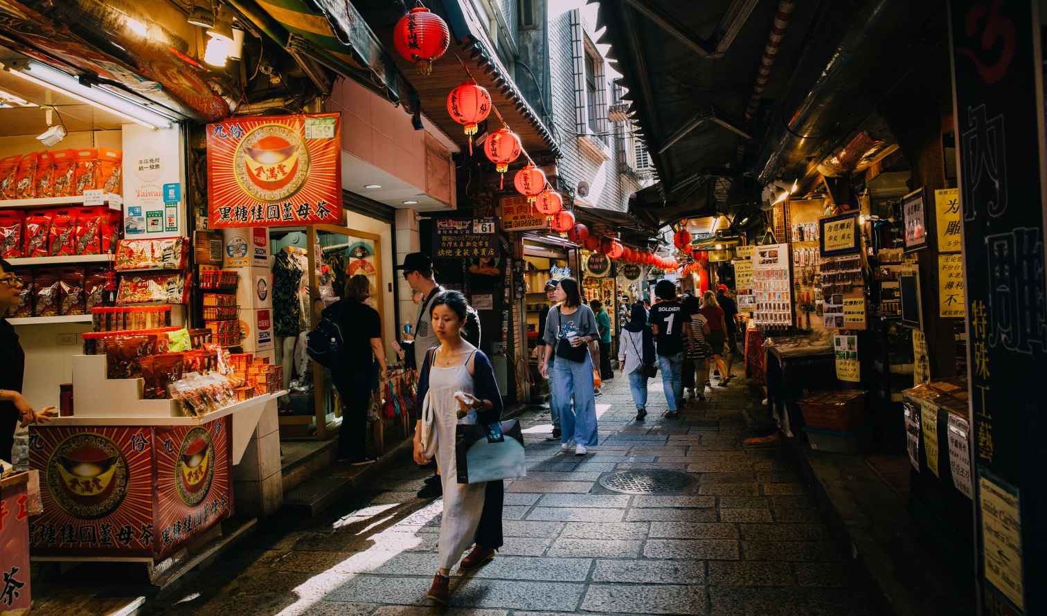 People walking through Jiufen Old Street market in Taiwan.