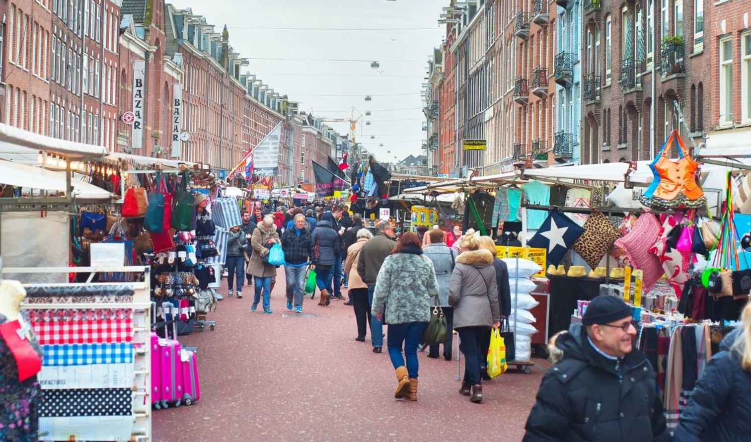 Street market on Albert Cuypstraat in Amsterdam with people shopping.
