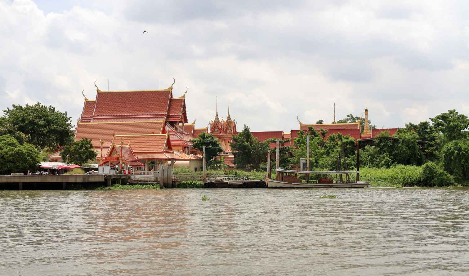 Wat Chalong temple visible near a river in Bangkok, Thailand.