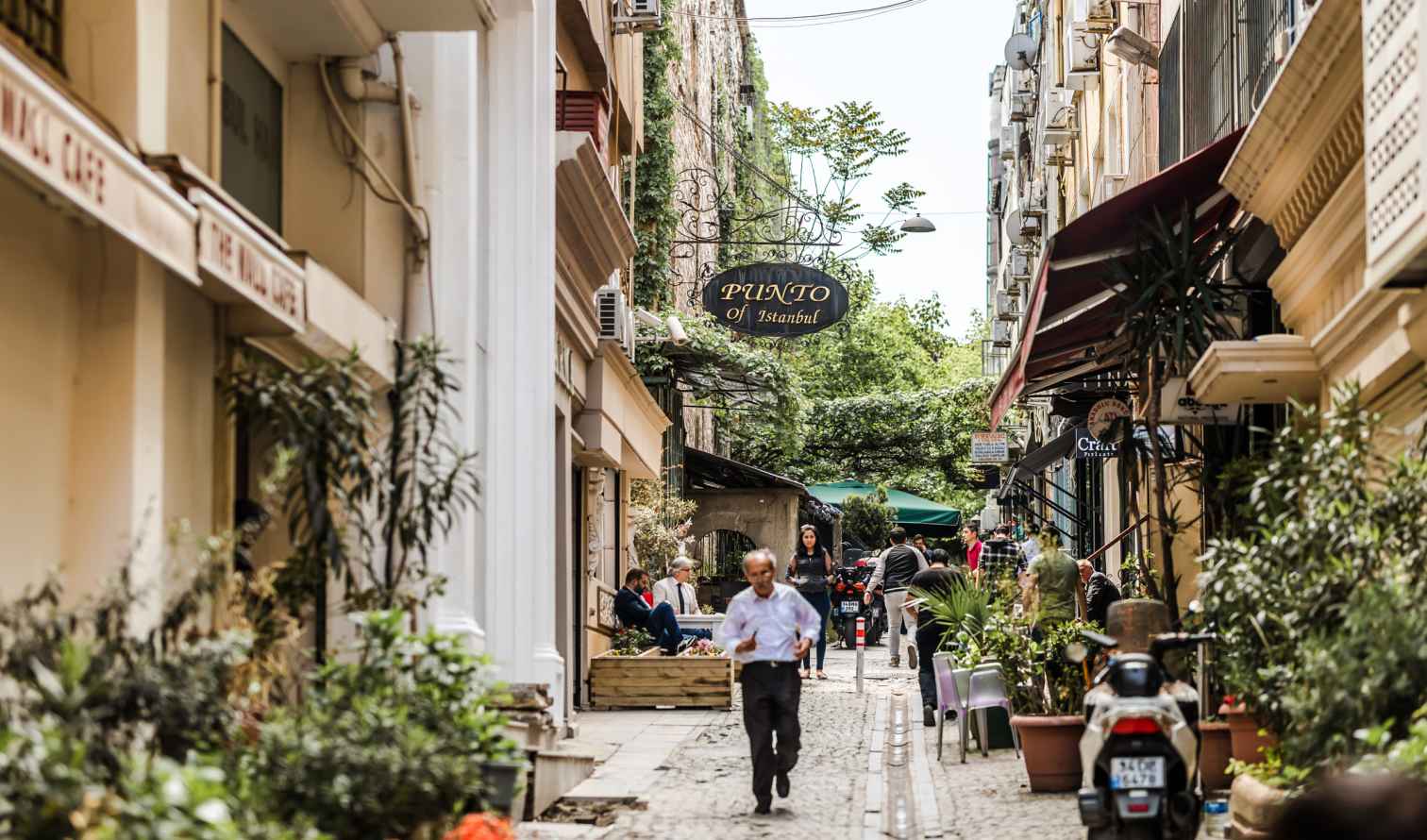 Narrow street with cafes, shops, and people in Istanbul.