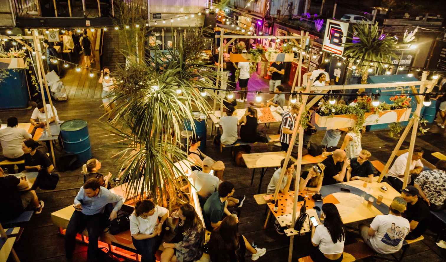 Decorative plants and diners in Pop Brixton, London, UK.