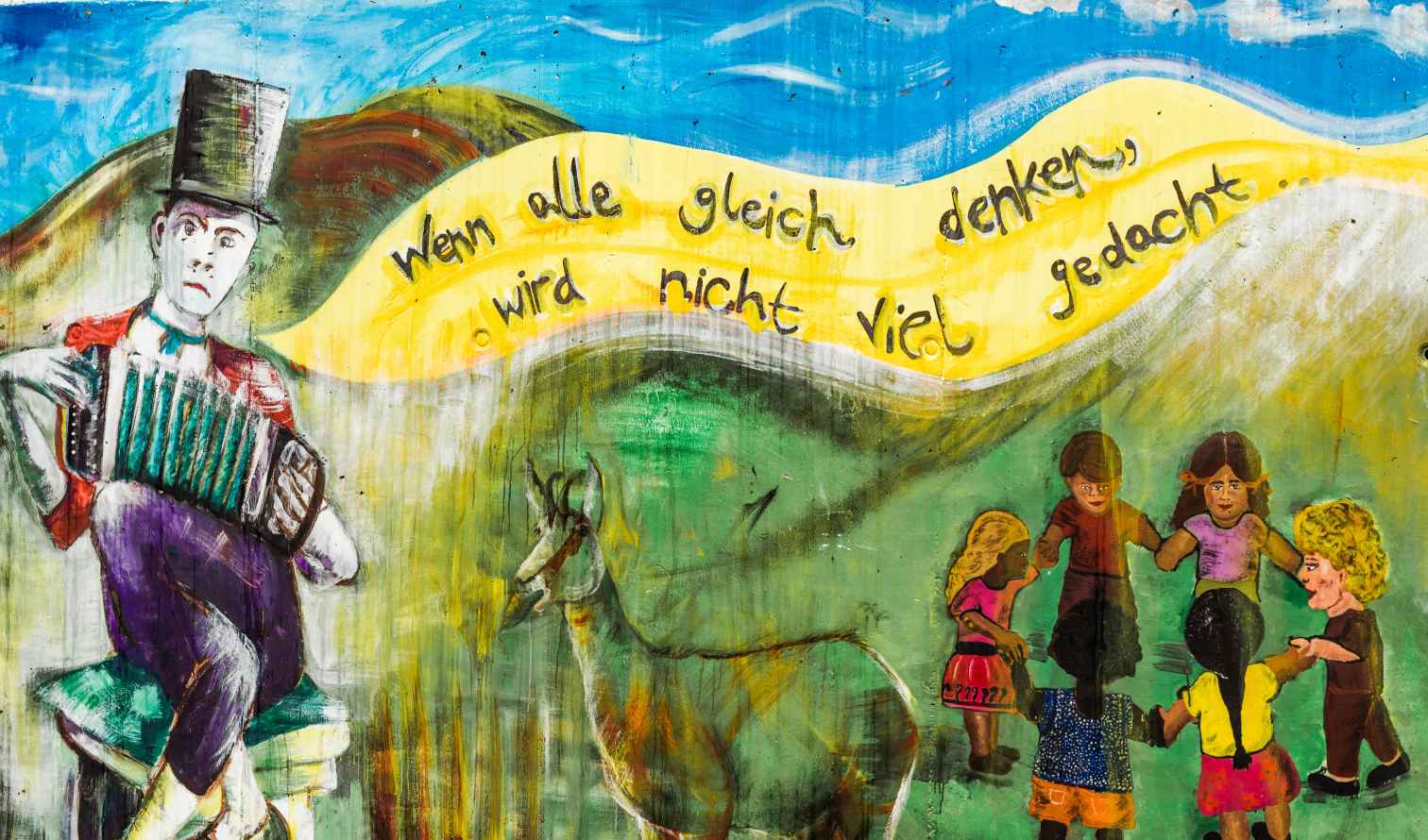 Children holding hands next to an animal in a colorful mural Munich