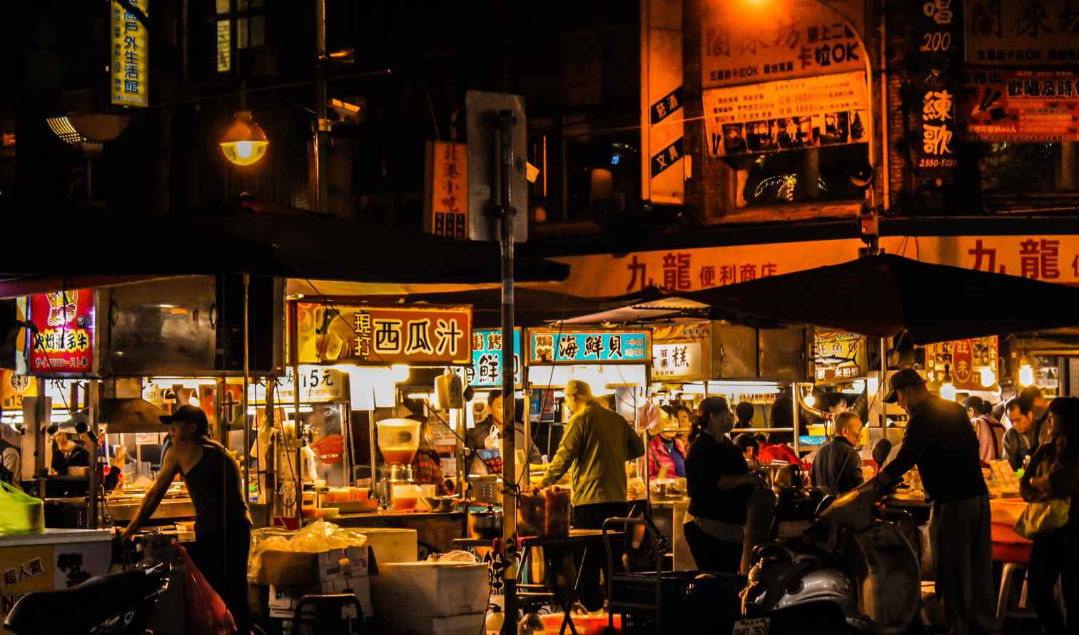 Busy street market stalls illuminated at night in Taipei, Taiwan.