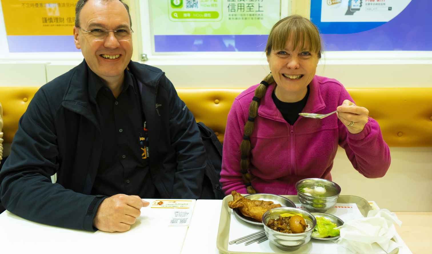 Two people seated at a dining table with food in front of them in Taipei