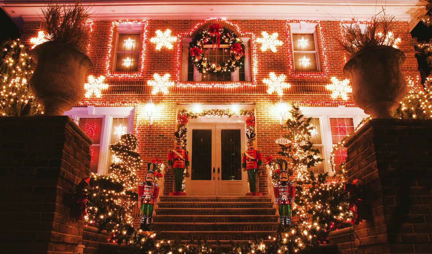 Lit Christmas decorations adorn a two-story brick house in New York