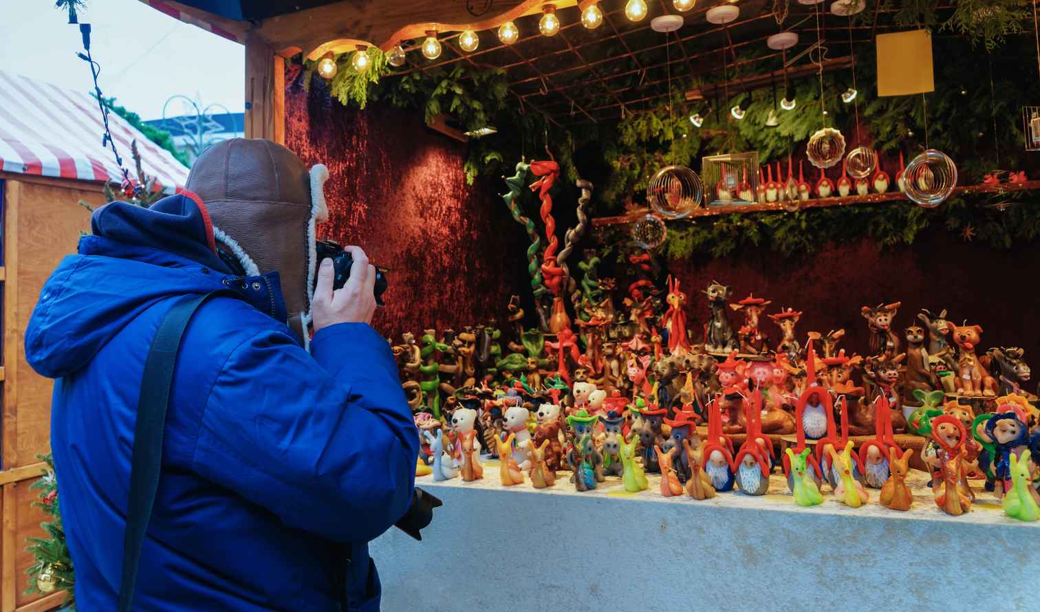 Person takes photo of clay figures at a Christmas market stall in Berlin