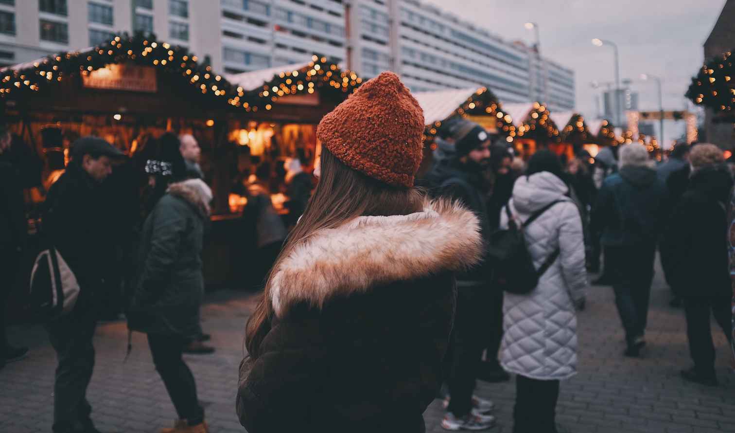 A woman in an orange hat at a Christmas market in Berlin.