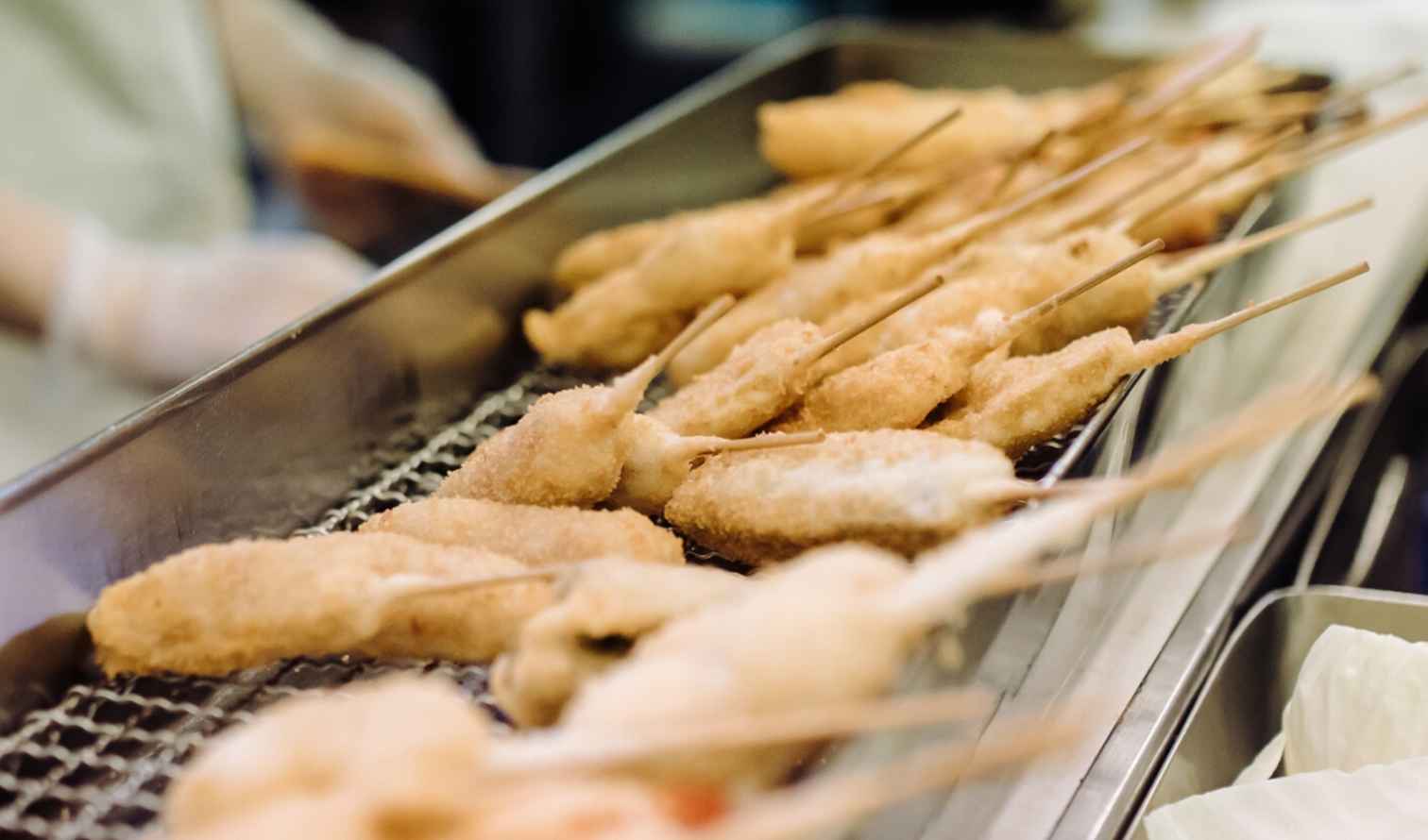 Close-up of skewered fried foods on a rack in a kitchen in Osaka