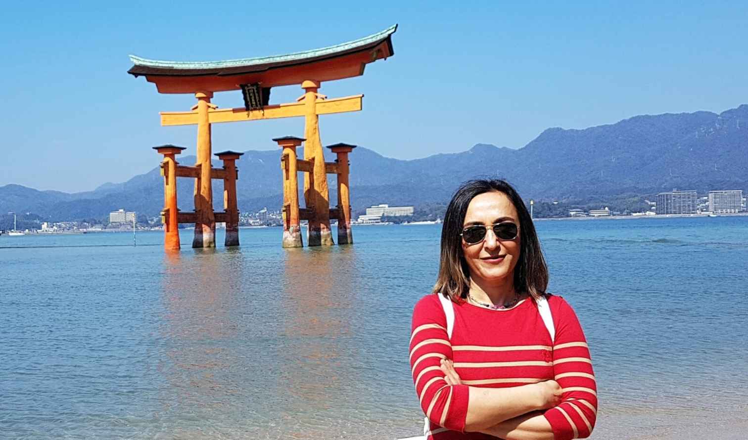 Person standing near the Itsukushima Shrine torii gate in Fukuoka