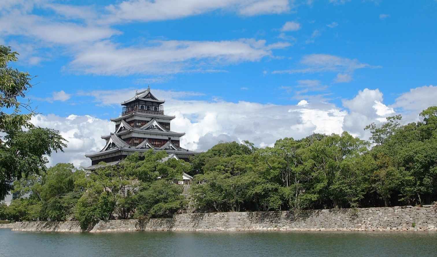 View of Hiroshima Castle's traditional architecture from across the water.