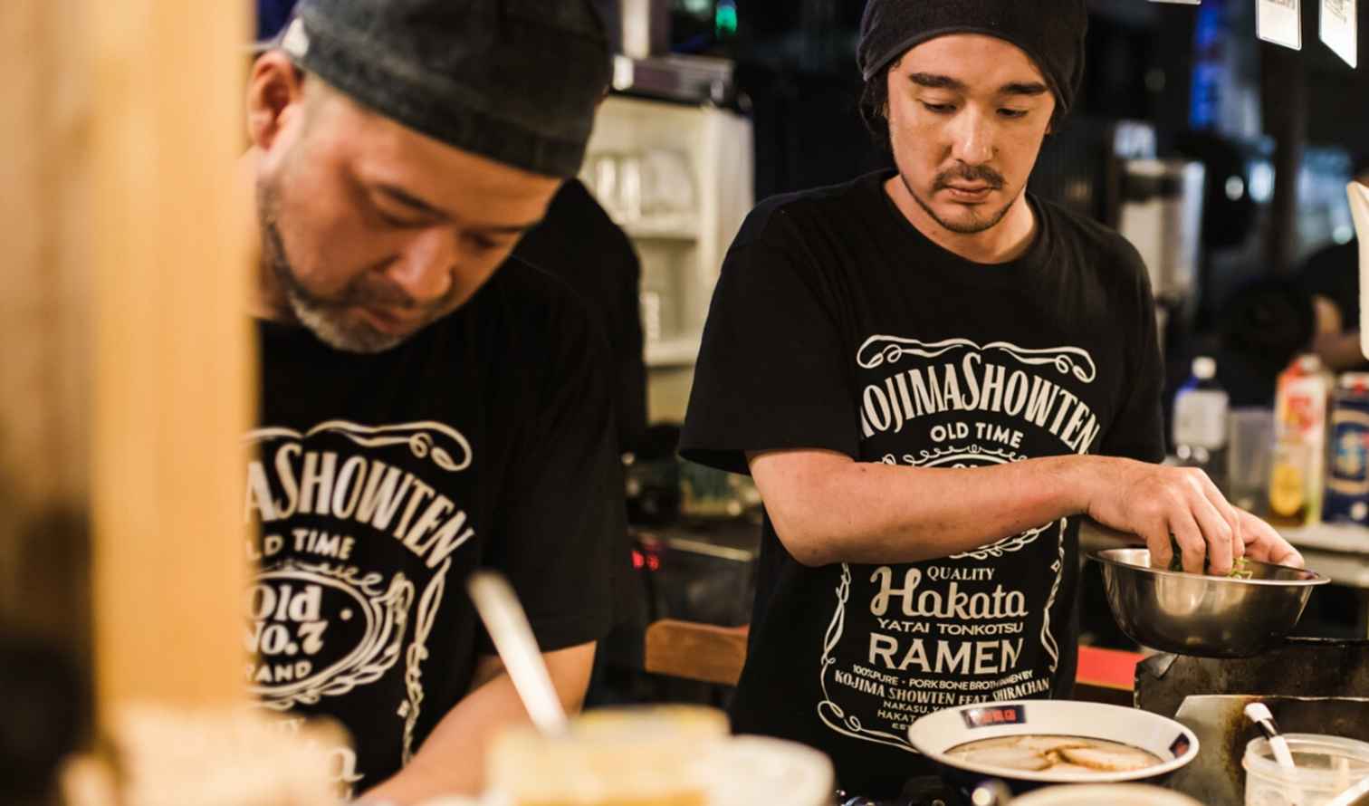 Two chefs preparing ramen at a food stall in Fukuoka