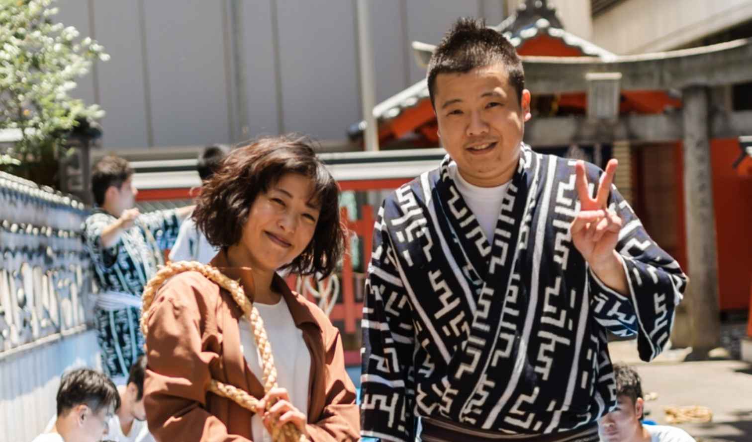 Two people in traditional clothing in front of a Japanese shrine in Fukuoka