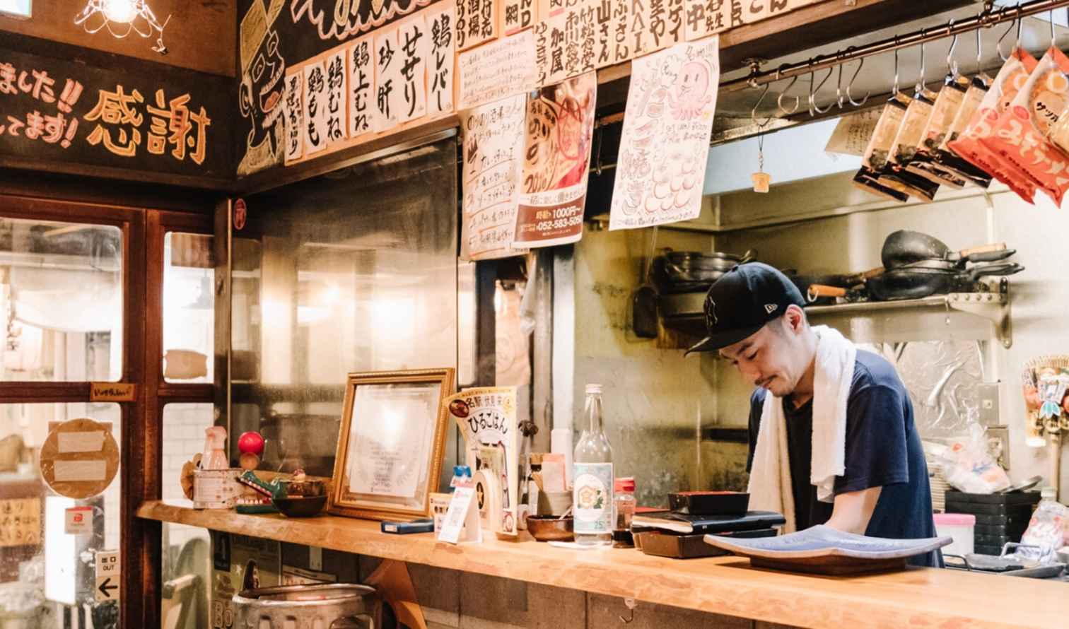 A chef working behind the counter in a small Japanese restaurant in Nagoya