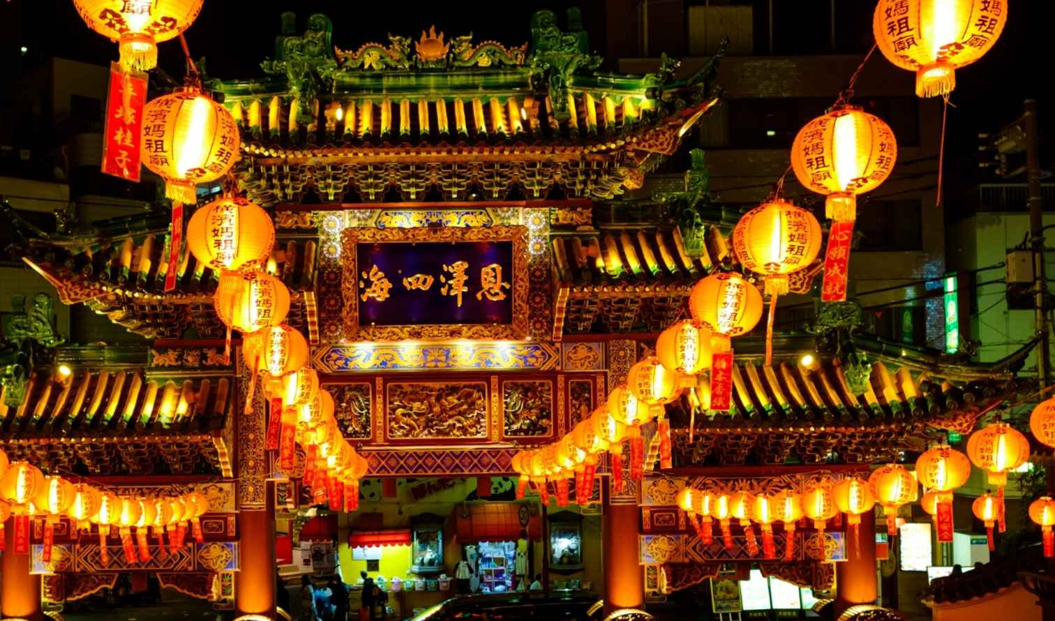 Bright lanterns hanging at the entrance to Yokohama Chinatown at night.