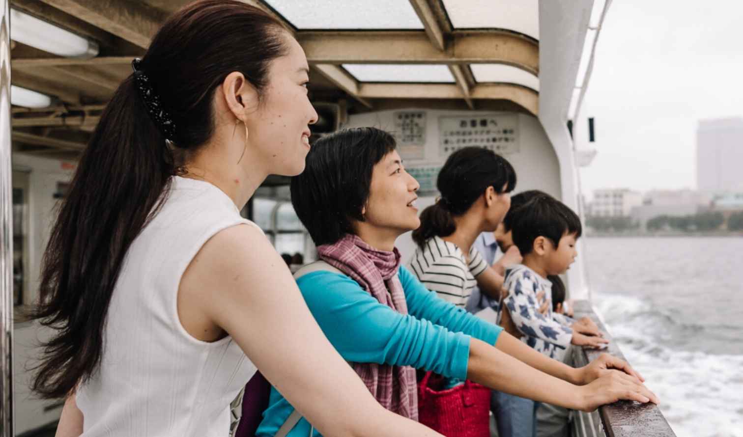 Passengers on a ferry admire the Yokohama skyline.