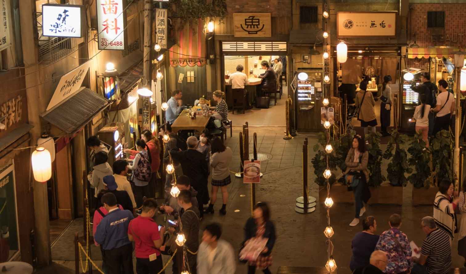 Japanese alley scene with diners and illuminated signs in an urban area in Yokohama
