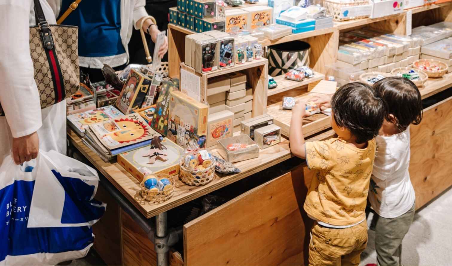 Children looking at toys on a wooden display in a shop in Yokohama