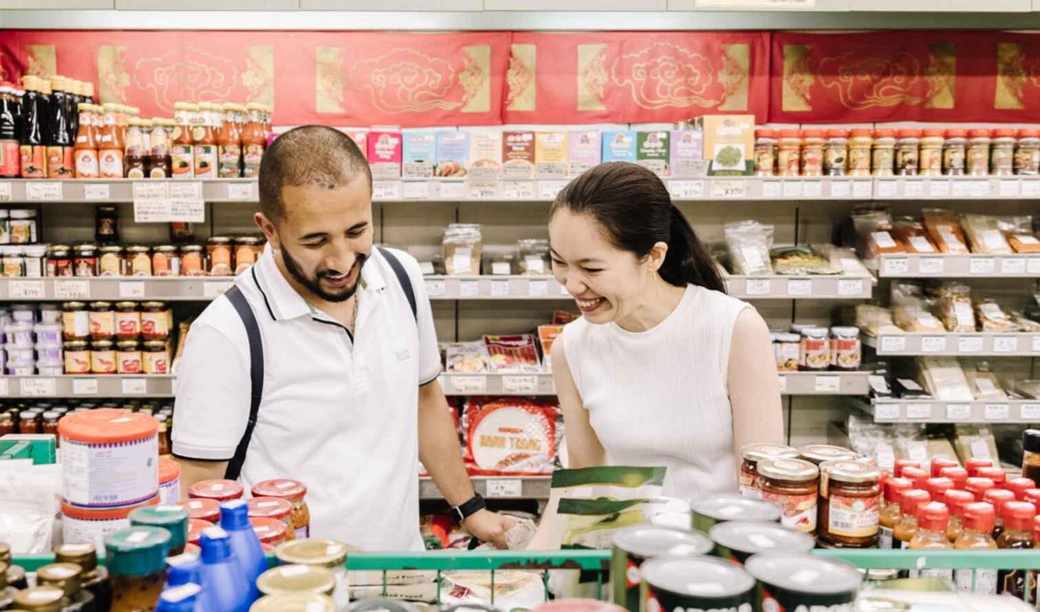 Man and woman standing in front of shelves of groceries in Yokohama