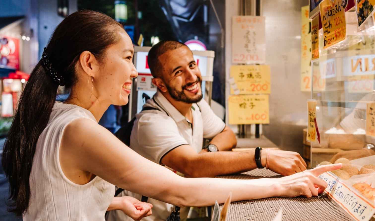 Two people ordering food at a street vendor in Yokohama.