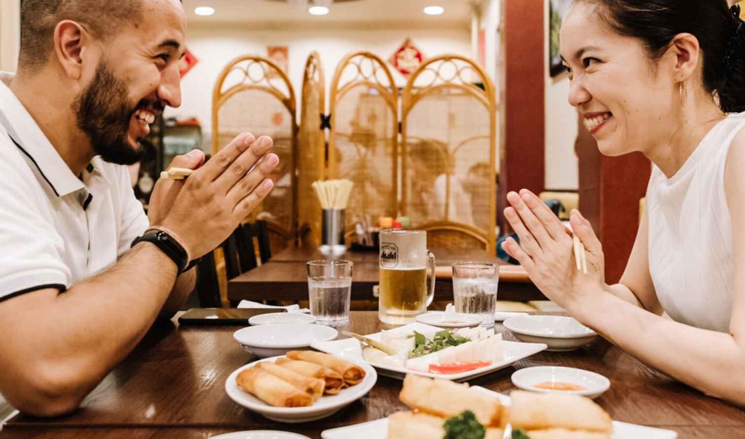 Two people seated at a wooden table in a restaurant discussing in Yokohama