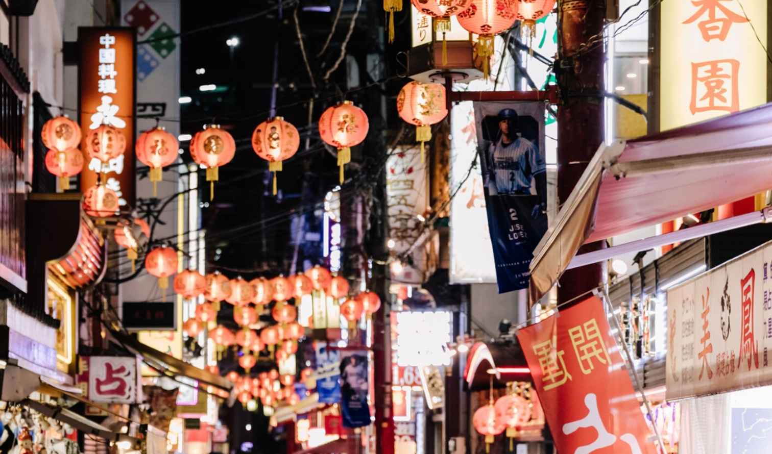 Chinese lanterns hanging above a street in Yokohama Chinatown at night.