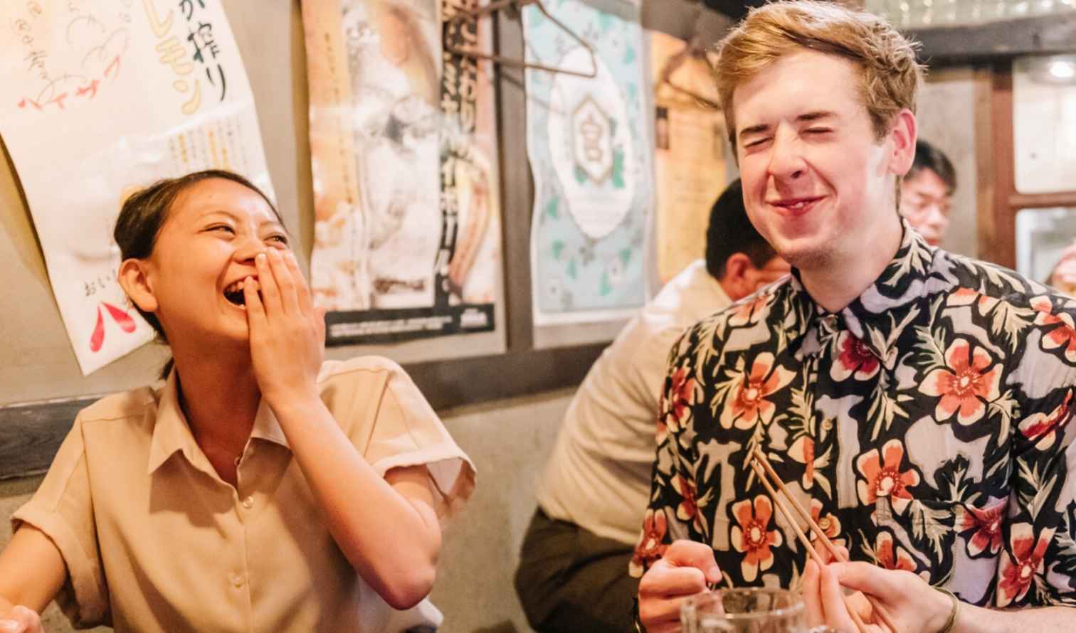 Two people laughing at a table in a Japanese restaurant in Nagoya