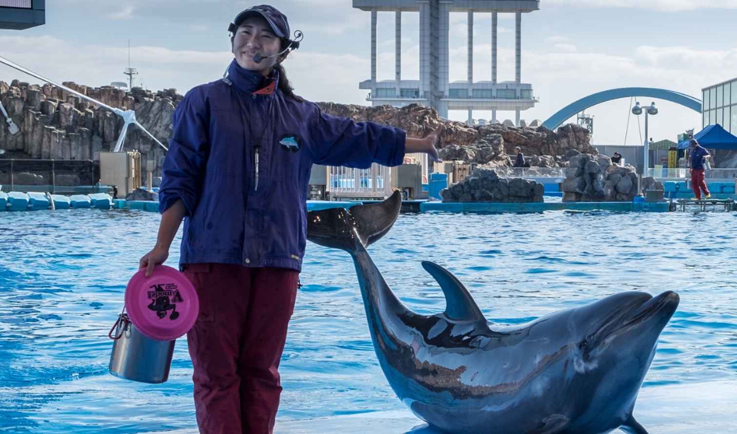 Two trainers and a dolphin at Port of Nagoya Public Aquarium.