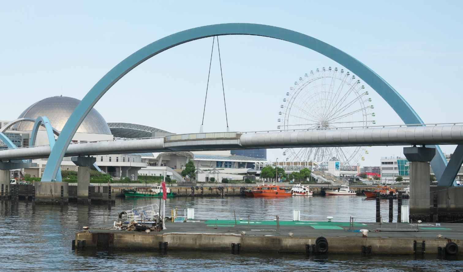 Bridge over the water with Nagoya Aquarium Kaiyukan and Ferris wheel visible.