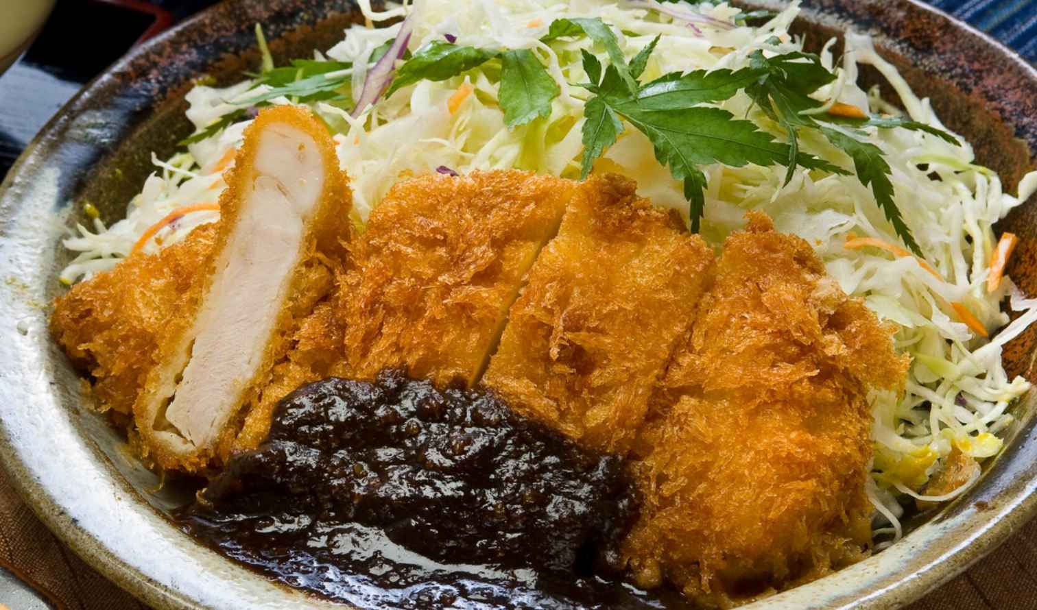 Close-up of crispy breaded pork cutlet served with shredded cabbage in Nagoya