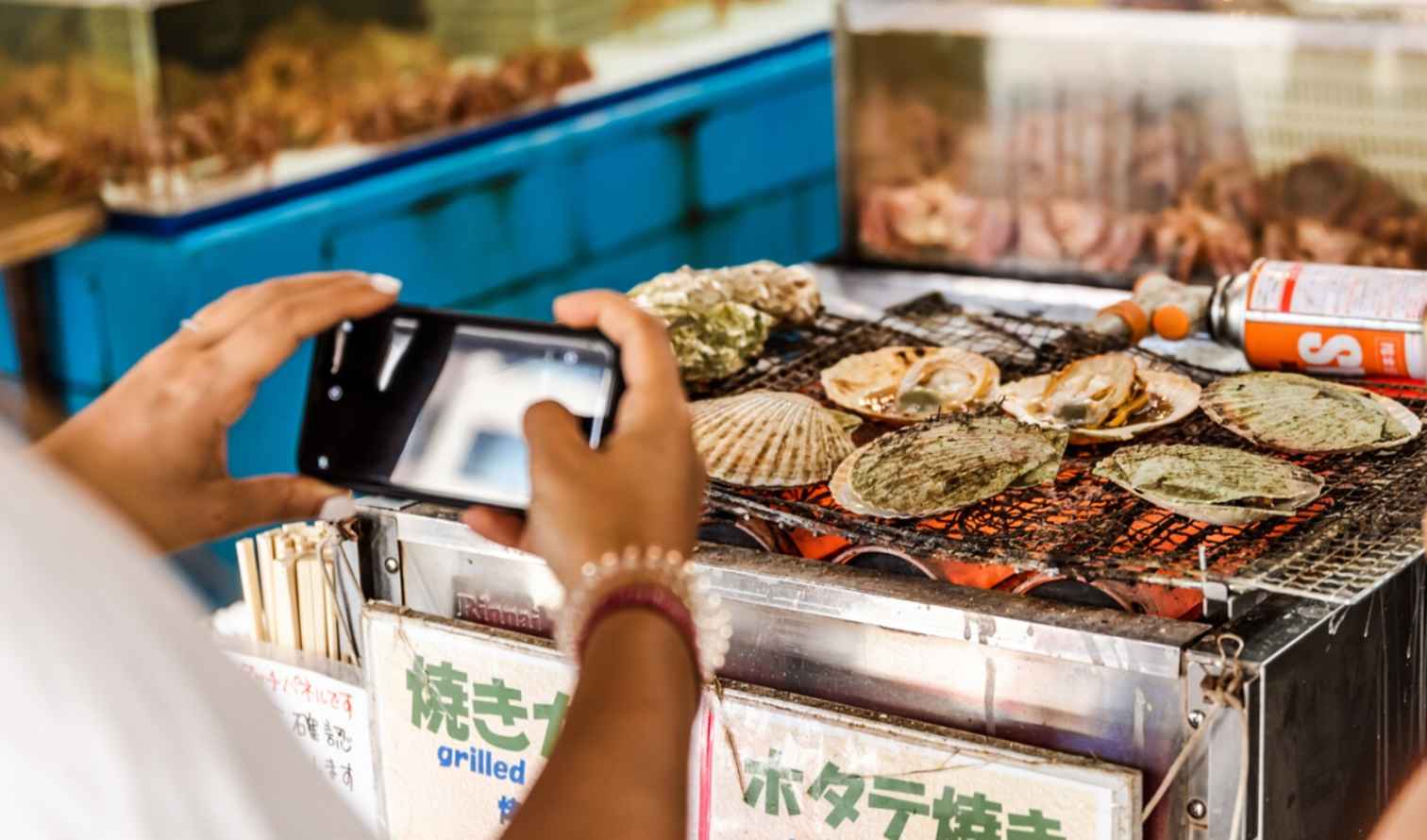Street food stall with grilled seafood being photographed in Sapporo