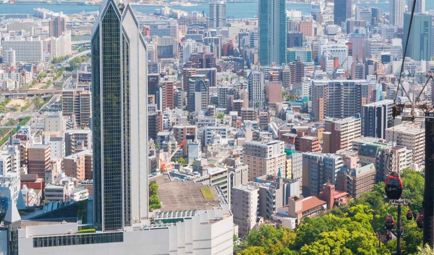 Aerial view of Kobe city with cable cars and skyscrapers.