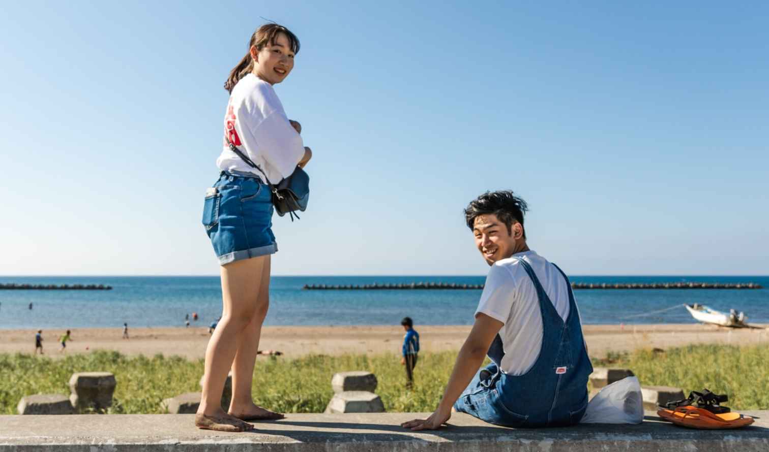 Two people sitting near the beach at a seaside location in Sapporo