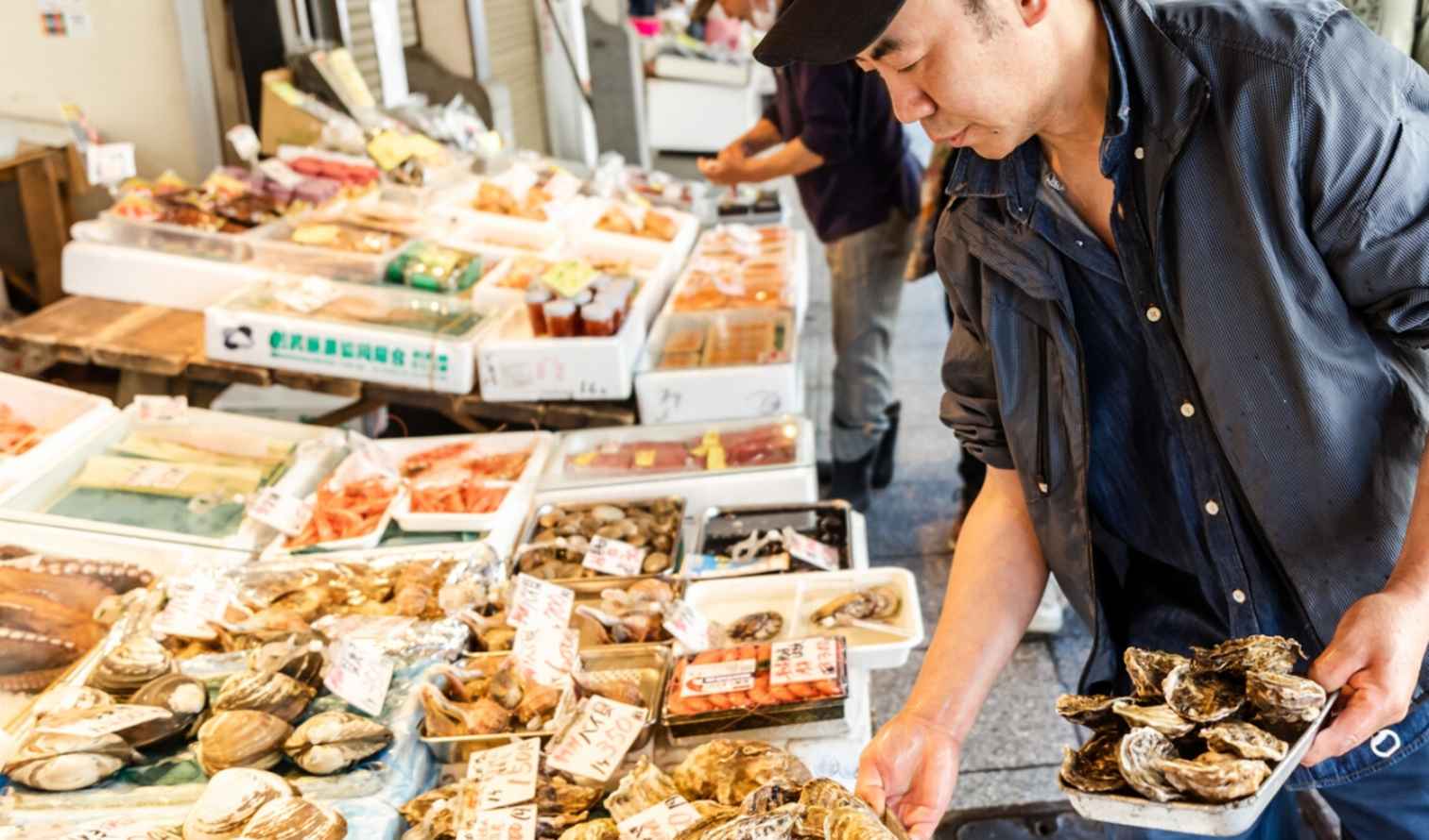 Man selecting seafood at a market stall in Sapporo