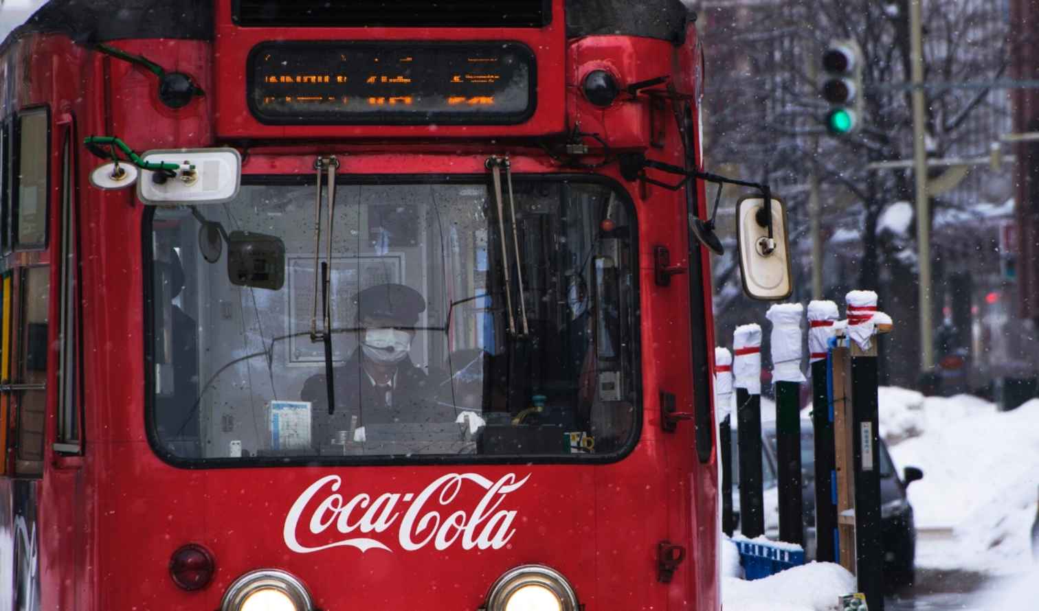 Red streetcar with Coca-Cola logo in snowy Sapporo, Japan.