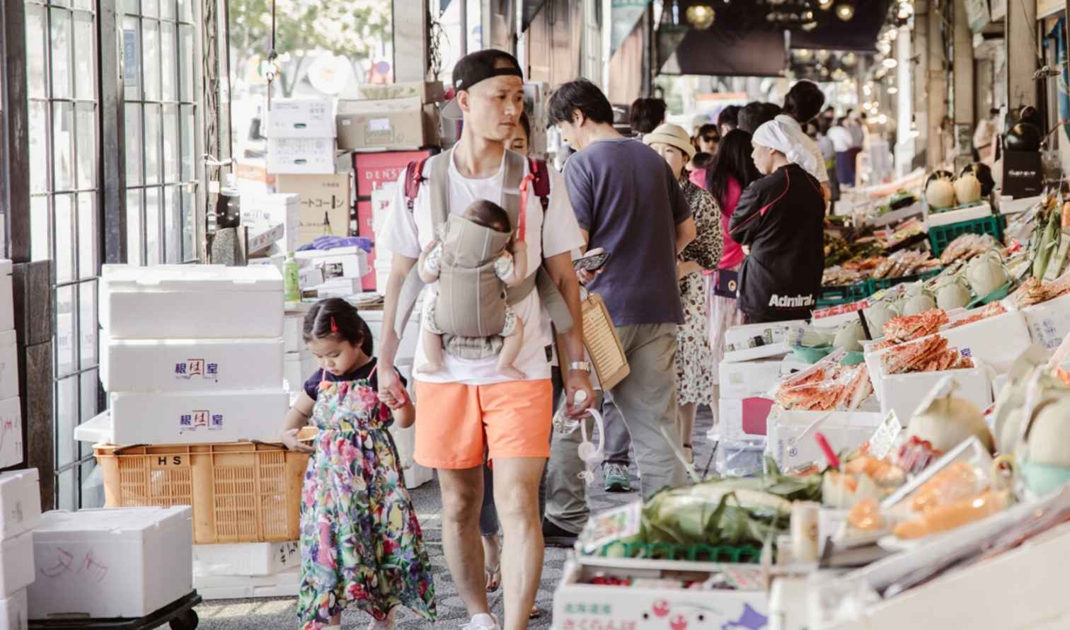 People walking through a fruit market in Tsukiji, Sapporo.