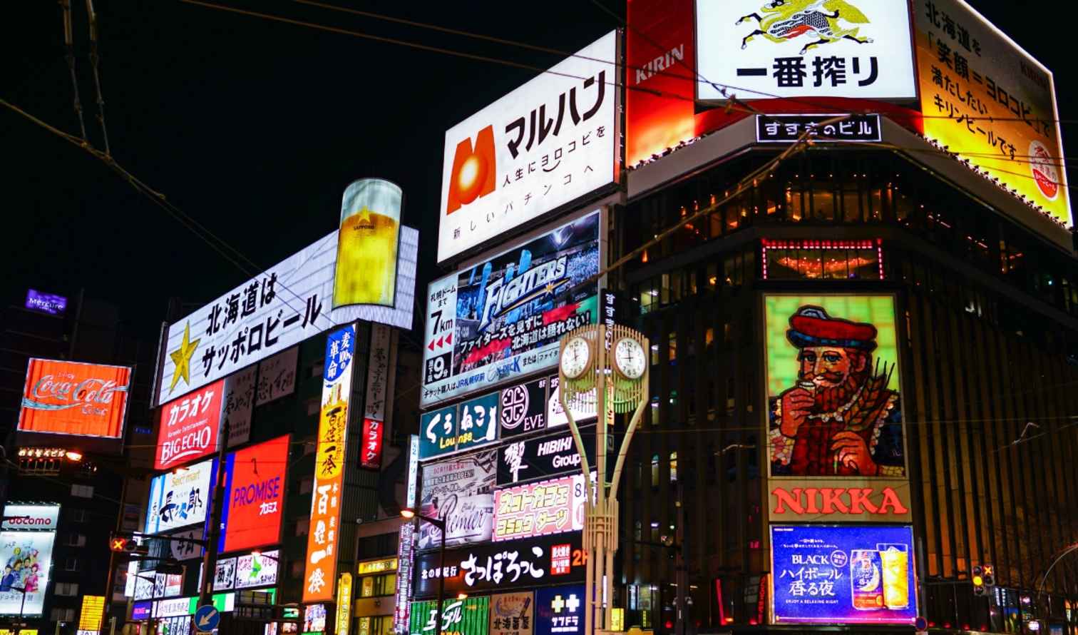 Neon signs in Susukino, Sapporo, featuring colorful advertisements at night.