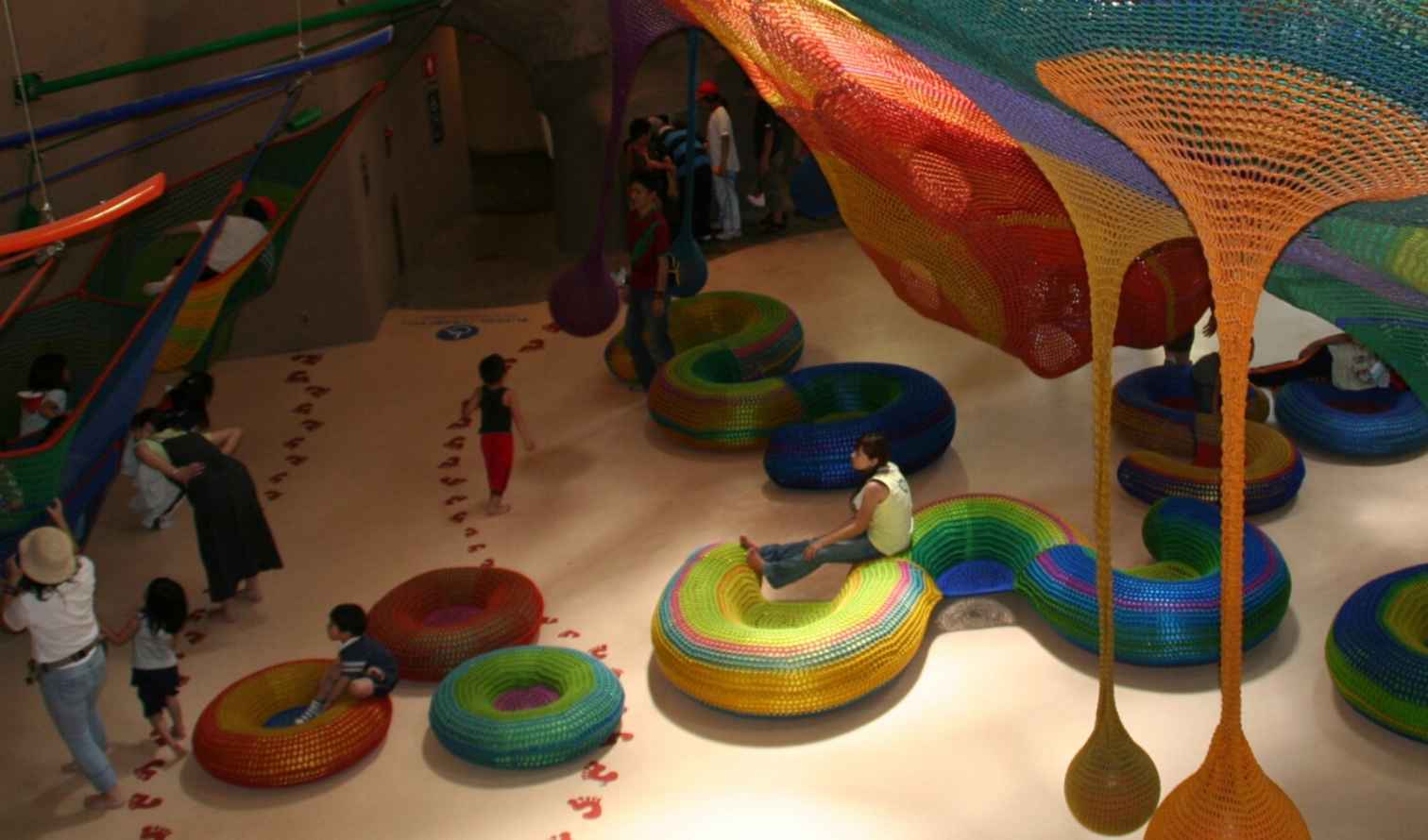 Children playing on colorful textile structures at Hakone Open-Air Museum, Japan.