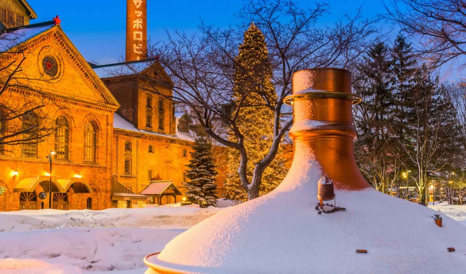 Snow blankets the Sapporo Beer Museum courtyard, highlighting brick architecture.