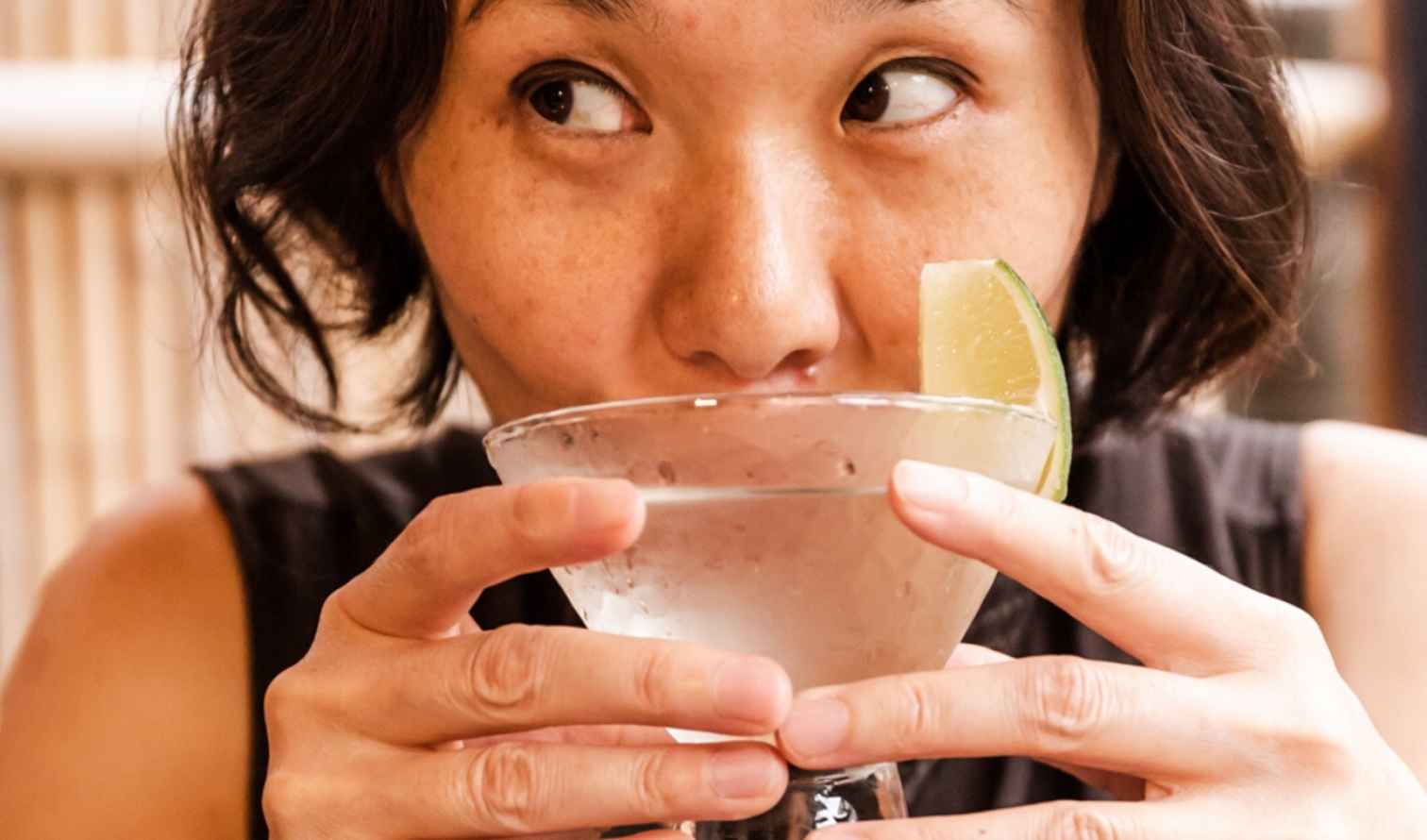 Person holding a martini glass with a lime wedge in Sapporo