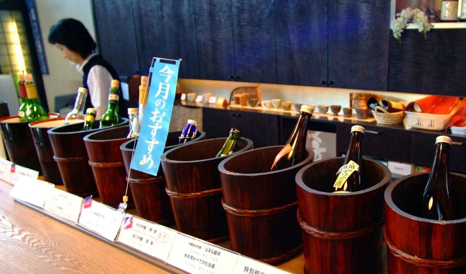 Sake bottles in wooden tubs on a bar counter in a Japanese restaurant in Sapporo