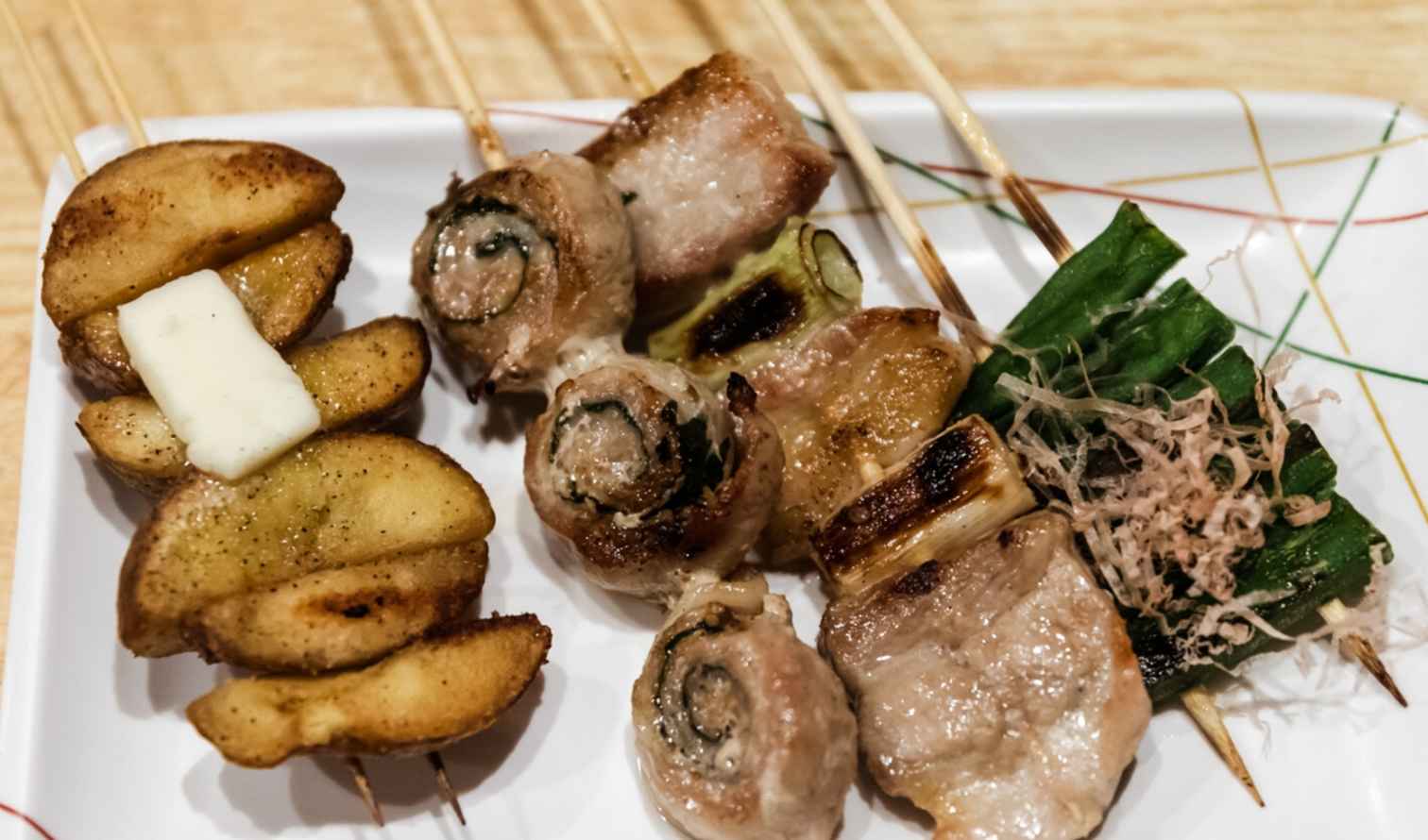 Plate of assorted yakitori skewers on a wooden table in Sapporo