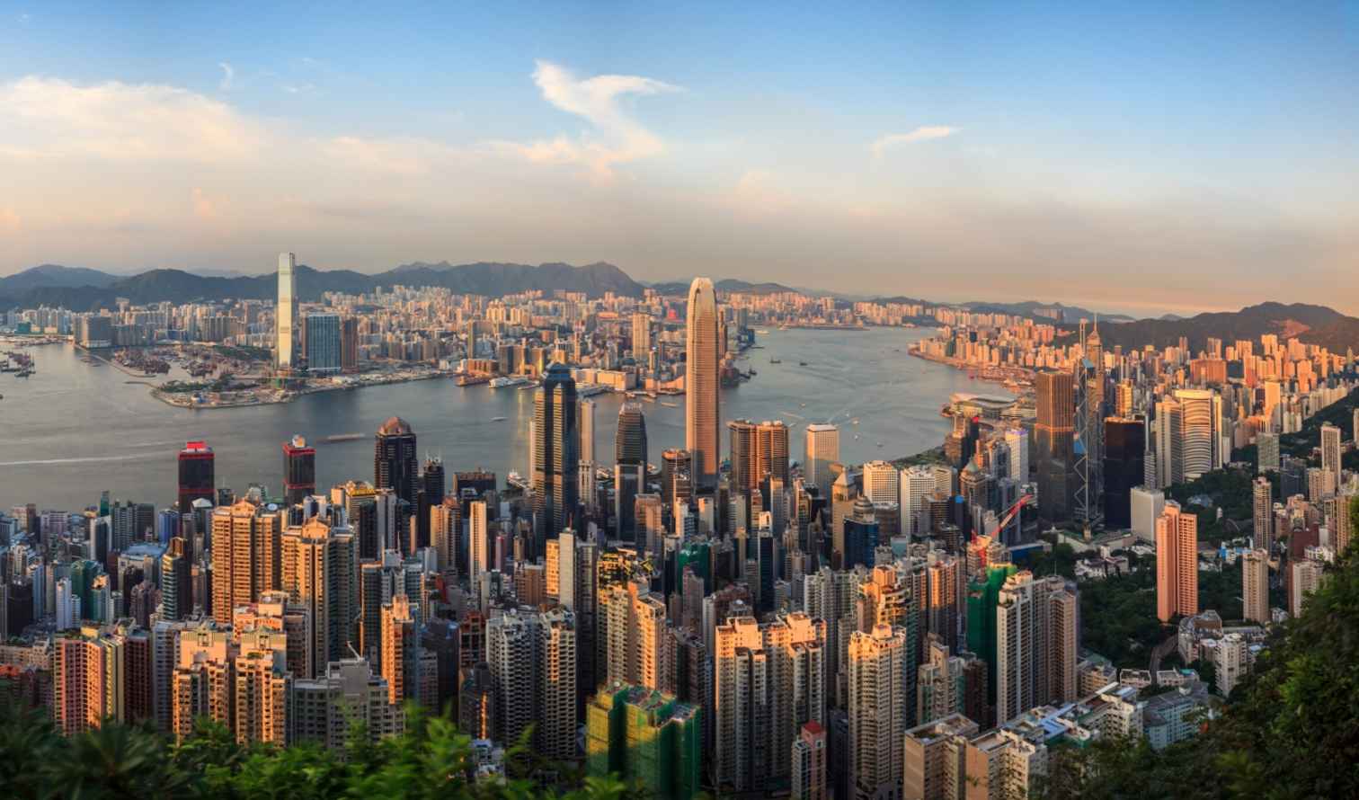 Aerial view of Hong Kong skyline and Victoria Harbour at sunset.