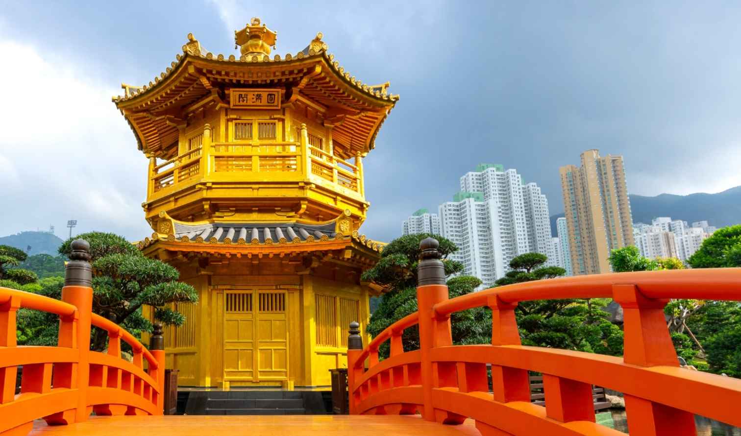 Golden pavilion in Nan Lian Garden, Hong Kong with red bridge.