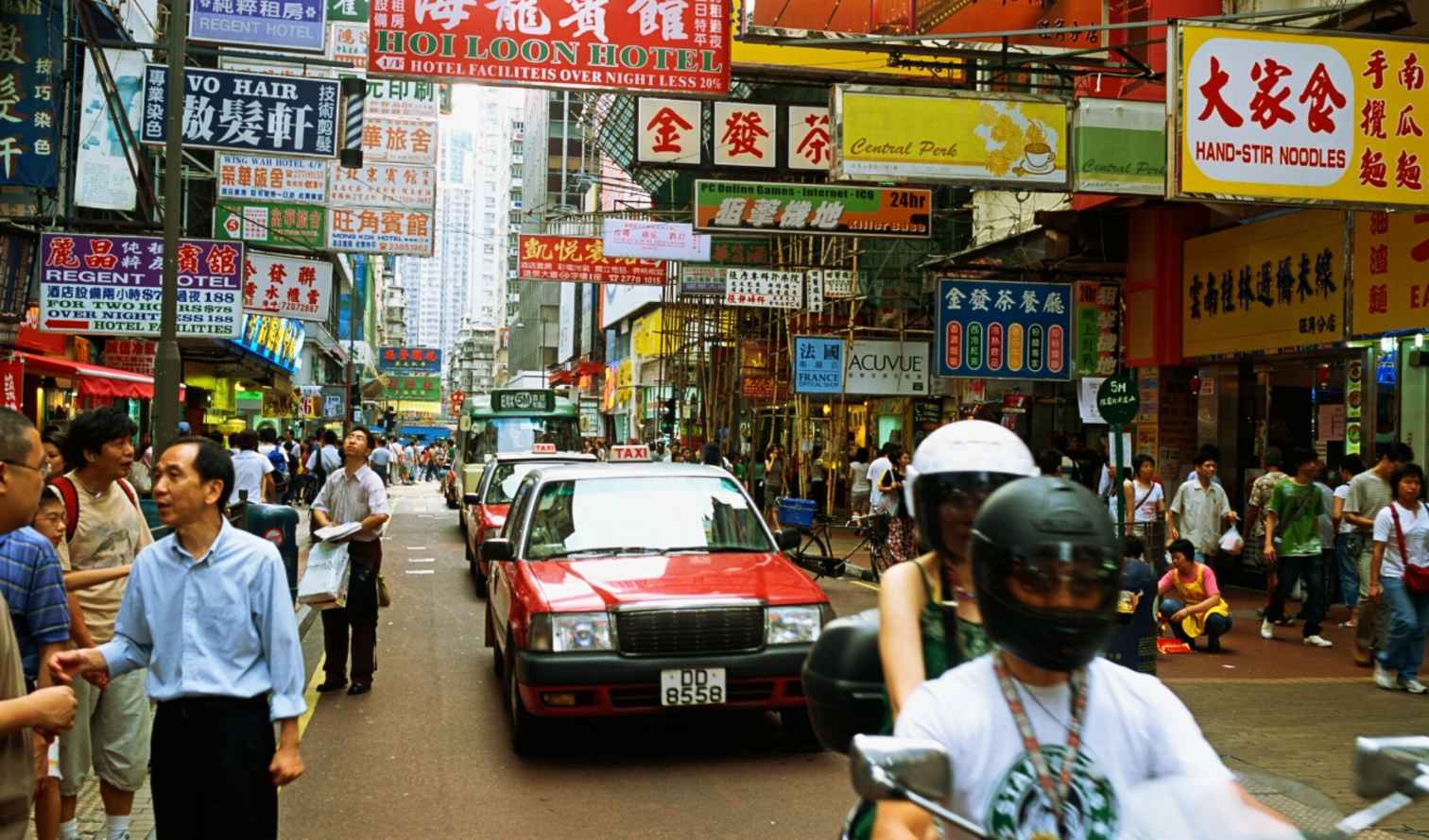 Pedestrians walk along a busy street in Kowloon, Hong Kong.